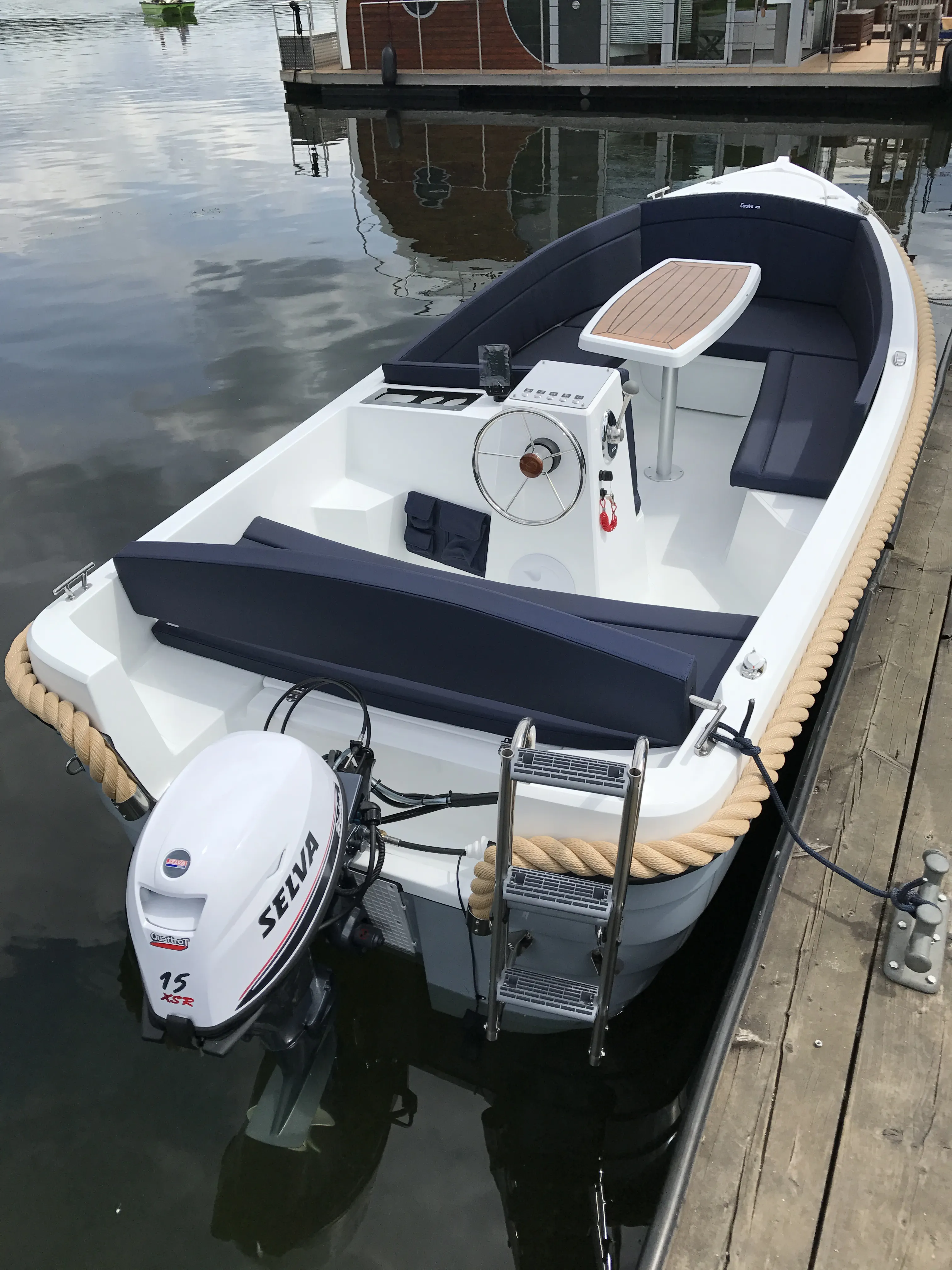 Ansicht von schräg hinten mit Motor, Cockpit und Sitzgruppe mit Tisch.